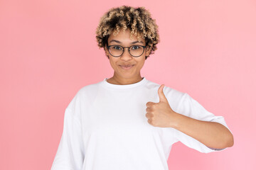 Portrait of content African American woman. Female model in glasses with curly hair looking at camera, gesturing. Portrait, studio shot, emotion concept