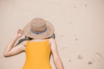 Woman tourist in yellow swimsuit and hat, happy traveler sunbathing at Paradise beach on Islands. destination, wanderlust, Asia Travel, tropical summer, vacation and holiday concept