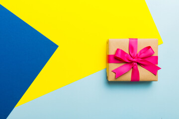 holiday paper present tied pink ribbon bow top view with copy space. Flat lay holiday background. Birthday or christmas present. Christmas gift box concept with copy space