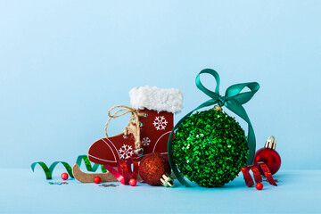 Christmas ball with skates on colored background. decoration bauble with ribbon bow with copy space