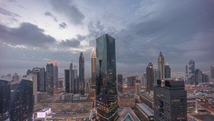 Obraz premium Panorama of futuristic skyscrapers after sunset in financial district business center in Dubai day to night timelapse