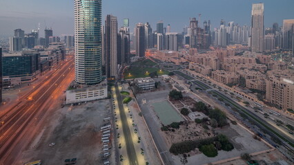 Dubai's business bay towers aerial night to day timelapse. Rooftop view of some skyscrapers
