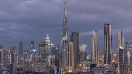 Panoramic skyline of Dubai with business bay and downtown district night to day timelapse.