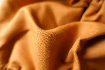 Soft folds on brownish orange hemp and cotton fabric