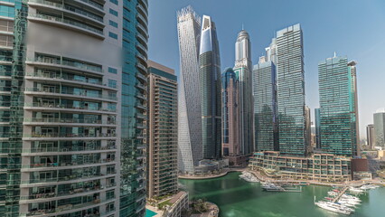 Naklejka premium Panorama showing Dubai marina tallest skyscrapers and yachts in harbor aerial timelapse.