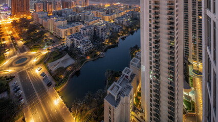 Pond and low rise buildings in Greens district aerial night to day timelapse.