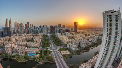 Sunrise over skyscrapers in Barsha Heights district and low rise buildings in Greens district aerial timelapse.