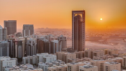 Sunrise over skyscrapers in Barsha Heights district and low rise buildings in Greens district aerial timelapse.