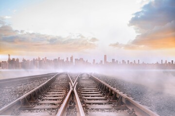 Train tracks leading to misty city on the horizon