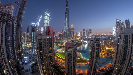 Panorama of Dubai Downtown cityscape with tallest skyscrapers around aerial night to day timelapse.