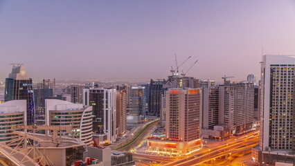 Fototapeta premium Skyscrapers at the Business Bay in Dubai aerial day to night timelapse, United Arab Emirates