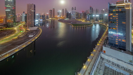 Fototapeta na wymiar Cityscape of skyscrapers in Dubai Business Bay with water canal aerial night to day timelapse