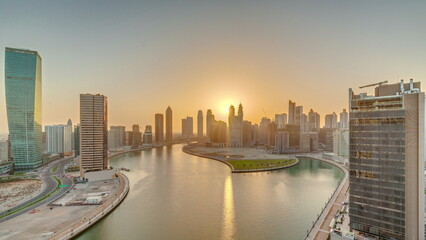 Fototapeta premium Sunset cityscape of skyscrapers in Dubai Business Bay with water canal aerial timelapse