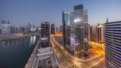 Fototapeta na wymiar Cityscape of skyscrapers in Dubai Business Bay with water canal aerial night to day timelapse