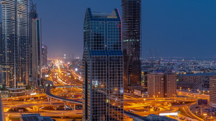 Dubai city skyline panoramic view with metro and cars moving on city's busiest highway aerial night to day timelapse