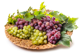 Clusters of white and pink grapes on a wicker dish. isolate on white background