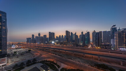 Dubai Marina skyscrapers and Sheikh Zayed road with metro railway aerial day to night timelapse, United Arab Emirates
