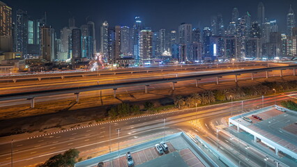 Panorama showing Dubai marina tallest block of skyscrapers night timelapse.