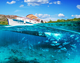 Split view - half underwater view of beautiful seabed with sea fishes and beautiful marine yacht,...