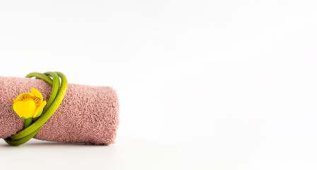 Pink terry towel, yellow water lily on a white background. Body care.