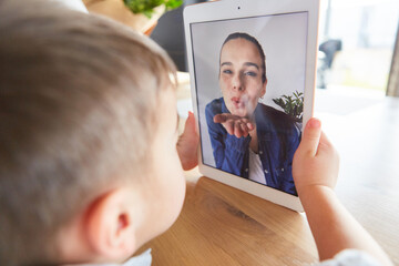 Mom gives her son an air kiss on the computer