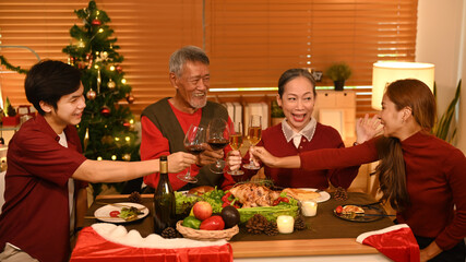 Happy family are clinking glass of wine during celebrating Christmas party dinner. Christmas and thanksgiving concept