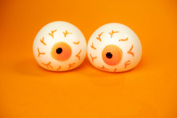 toy eyes on an orange background with a place for text, halloween concept