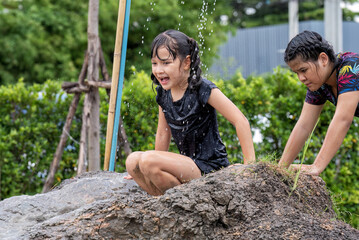 Kid enjoy playing on soil clay slider slide to muddy water below and splash the water in the air...