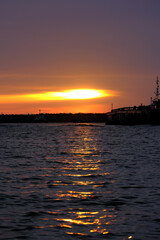Silhoutte sunset with light reflection on the water at the port.