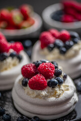 Mini Pavlova cakes topped with berries and mascarpone cheese