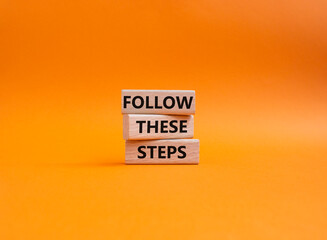 Follow these steps symbol. Wooden blocks with words Follow these steps. Beautiful orange...