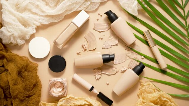 Bottles of three different shades of makeup foundation on beige background with palm leaf