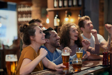 Cheering friends of soccer fans in the pub