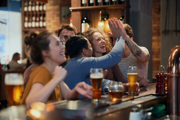 Cheering friends of soccer fans in the pub