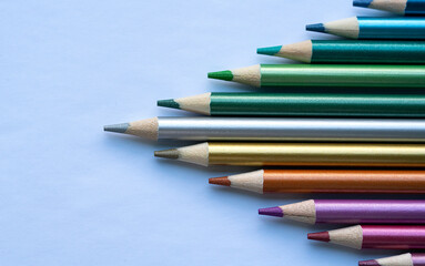 Fototapeta premium Colored pencils with a metallic sheen close-up. Background with place for text. High quality photo