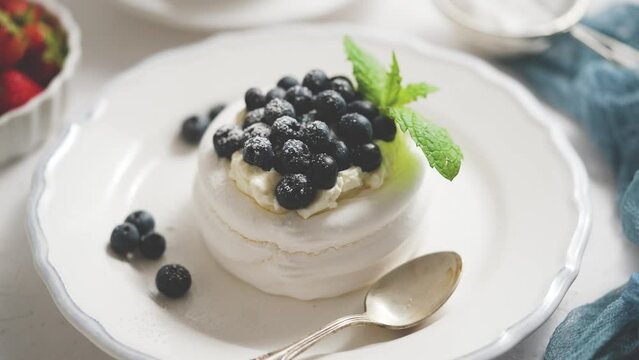 Delicious mini Pavlova meringue nest with blueberry and mint leaves