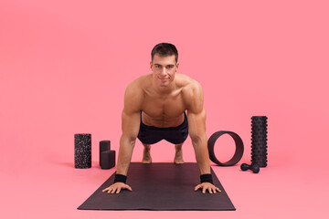 A man shows how to do a plank, techniques, variations. Athlete pushing up from the floor. Planks exercise for beginners.
