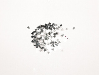 Silver glitter and glittering stars on gray background