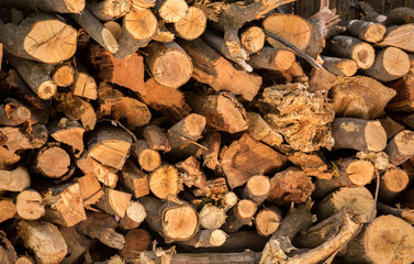 Firewood is split and stacked for the winter heating season. Background of stacked firewood, chopped wood for the stove.