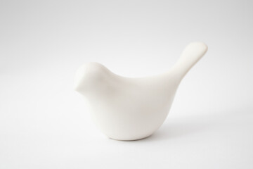 White ceramic toy bird on a white background