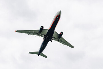 Passenger plane comes in for landing in cloudy weather.