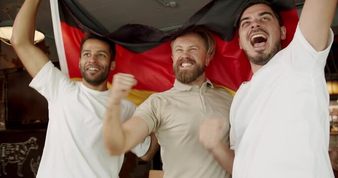Soccer fans celebrating victory of team in sports bar. Happy mixed race supporters cheering and exulting after winning. Happy Men with the flag of the national country of Germany