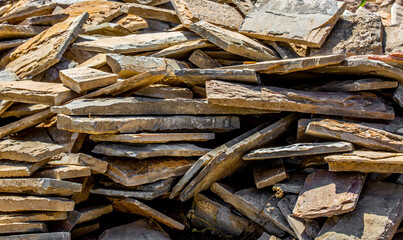 Firewood is split and stacked for the winter heating season. Background of stacked firewood, chopped wood for the stove.