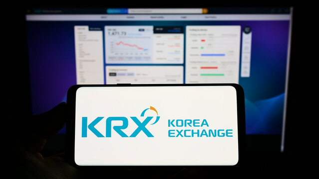 Stuttgart, Germany - 08-28-2022: Person holding smartphone with logo of financial marketplace Korea Exchange (KRX) on screen in front of website. Focus on phone display.