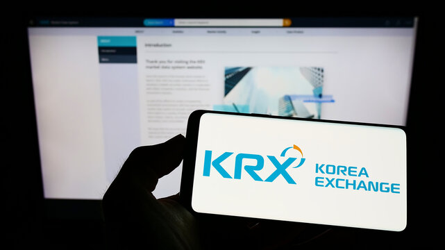 Stuttgart, Germany - 08-28-2022: Person holding cellphone with logo of financial marketplace Korea Exchange (KRX) on screen in front of company webpage. Focus on phone display.