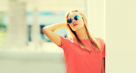 Summer portrait of stylish blonde young woman wearing sunglasses in the city