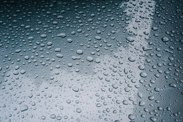 Condensation on the clear blue glass window. Water drops. Rain. Abstract background texture. Water drops on window glass. Close up.