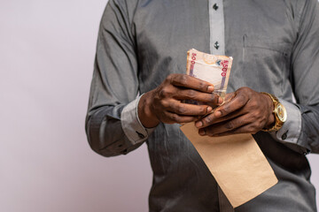 african man holding and envelope containing money
