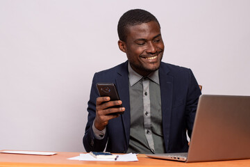 black businessman using his phone and laptop