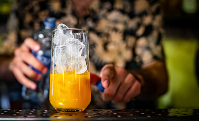 bartender making cocktail with fruit in a nightclub bar